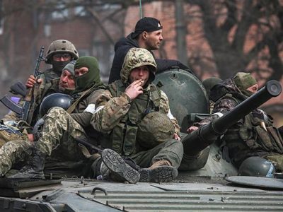 Anggota layanan pasukan Pro Rusia terlihat di atas kendaraan lapis baja selama konflik Ukraina-Rusia. Sumber foto : Reuters.